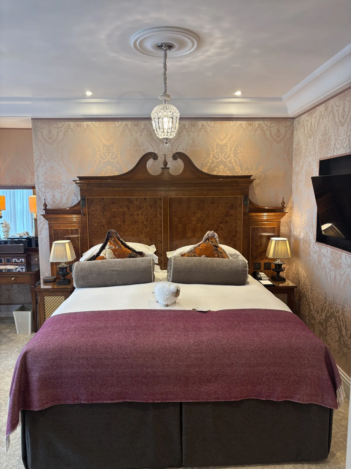 Suite bedroom at The Goring with marquetry headboard and crystal pendant light
