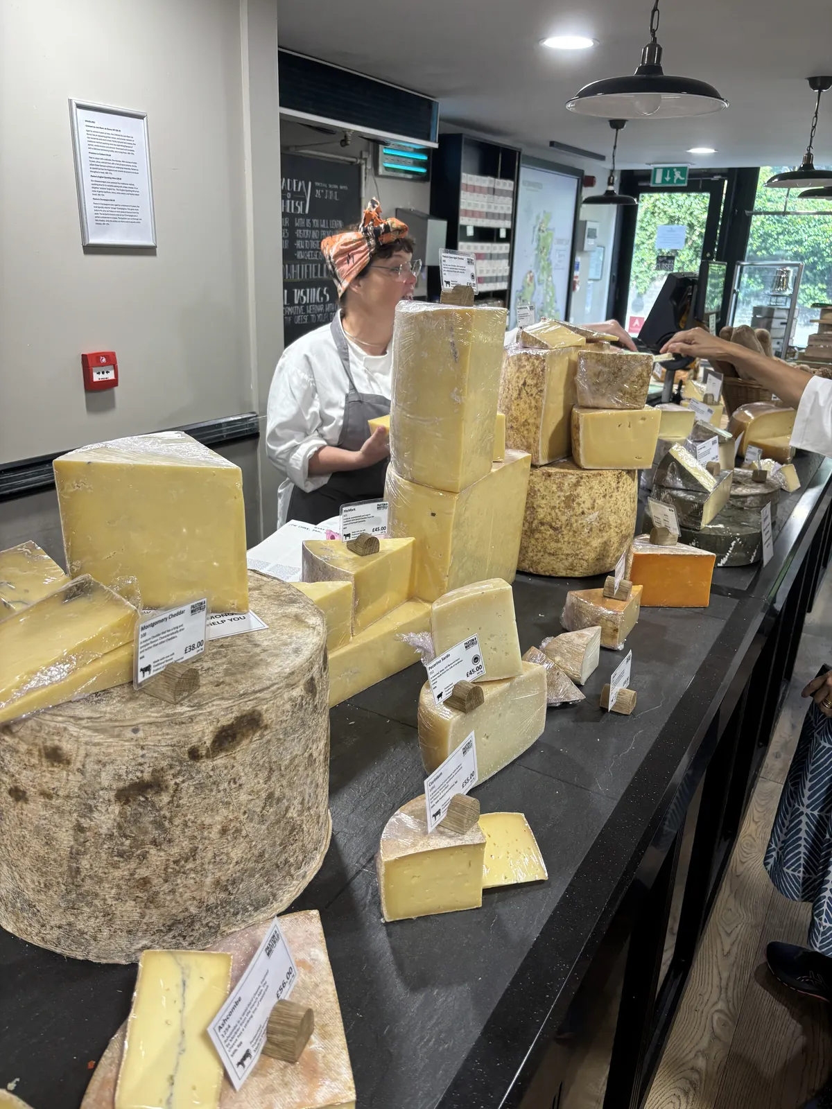 Wheels of English farmhouse cheese stacked at Paxton and Whitfield in London